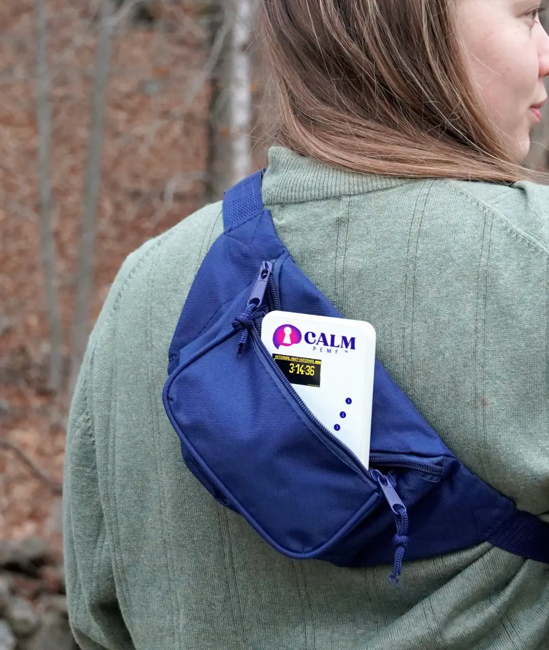 Teenage girl wearing CALM device in blue backpack on back