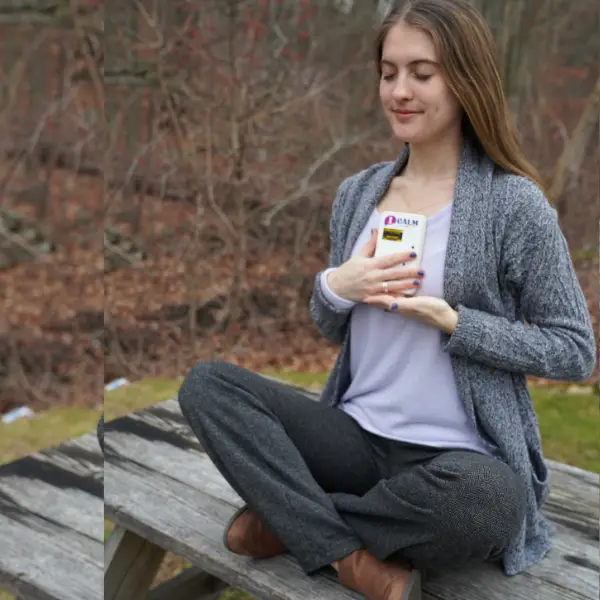 Teenage girl sitting outdoors on bench with CALM device in backpack