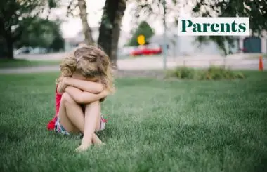 Child sitting outdoors featured in Parents magazine article about meltdowns