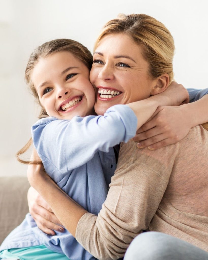 Mother and child smiling together in a warm, connected embrace