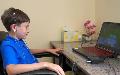 Child with scalp sensors watching a laptop during neurofeedback training