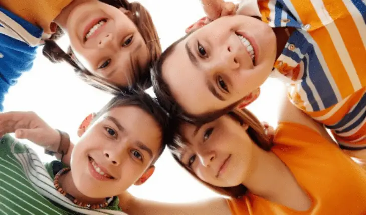 A circle of kids posing for a photo.