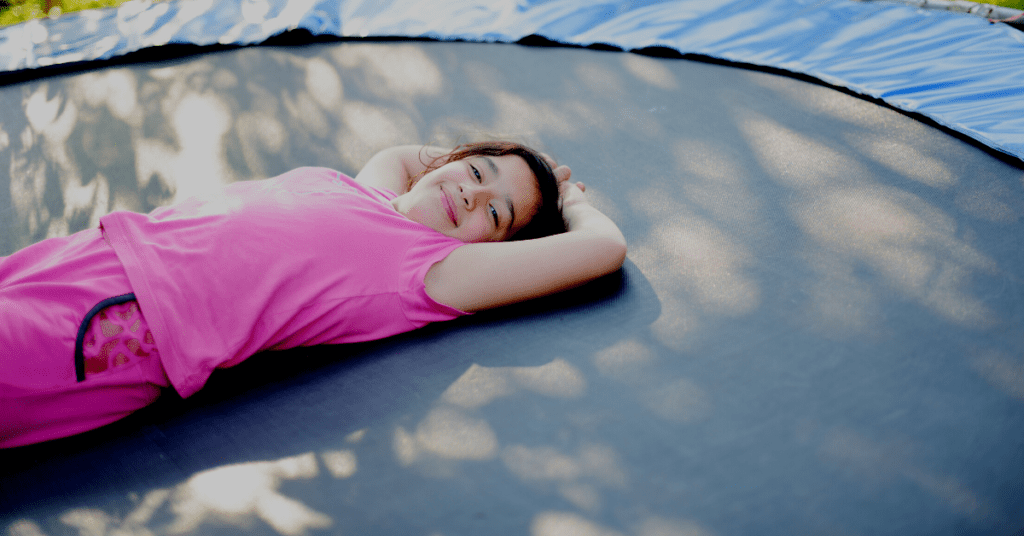 Child laying on a trampoline