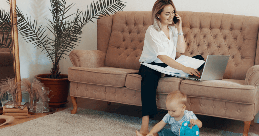 A multitasking woman balancing work and family on a couch at home.