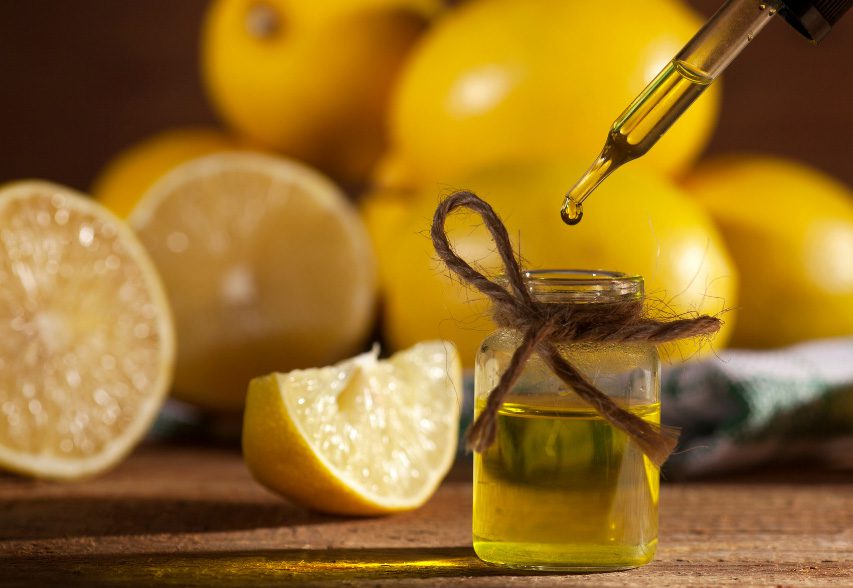 A bottle of lemon oil is being poured onto a wooden table, harnessing the power of essential oils for stress and anxiety relief.