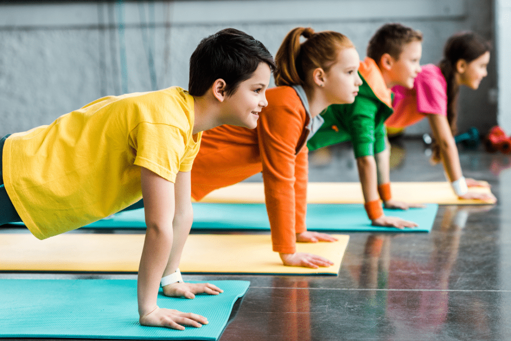 A group of children engaging in physical exercise at a gym.