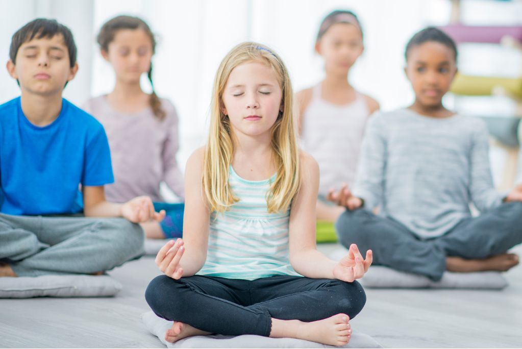 A group of children developing self-regulation and emotional intelligence through yoga.
