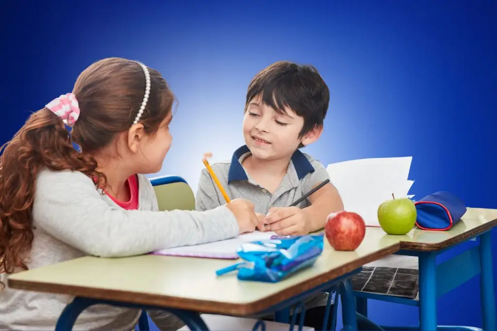 Two children engaged in a thoughtful conversation, facing each other with expressive gestures and attentive expressions, illustrating emotional communication and peer connection.